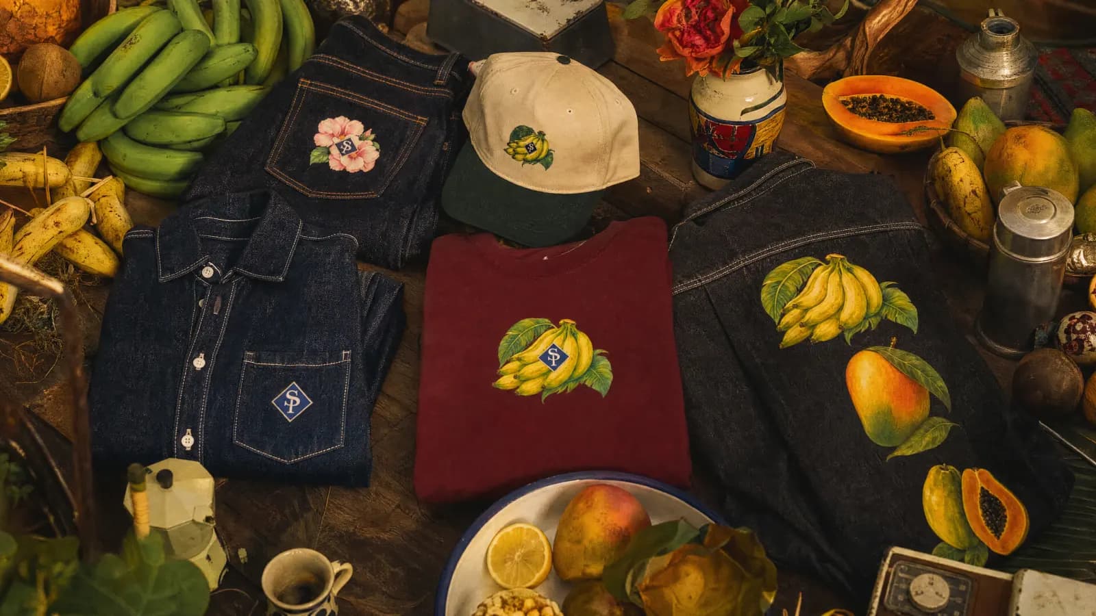 Vista cenital: mezclilla, gorra, camiseta vino y produce sobre madera